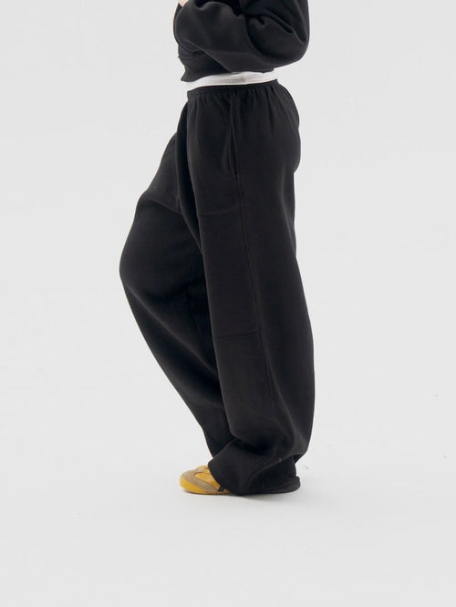 Person wearing a black outfit on a white background