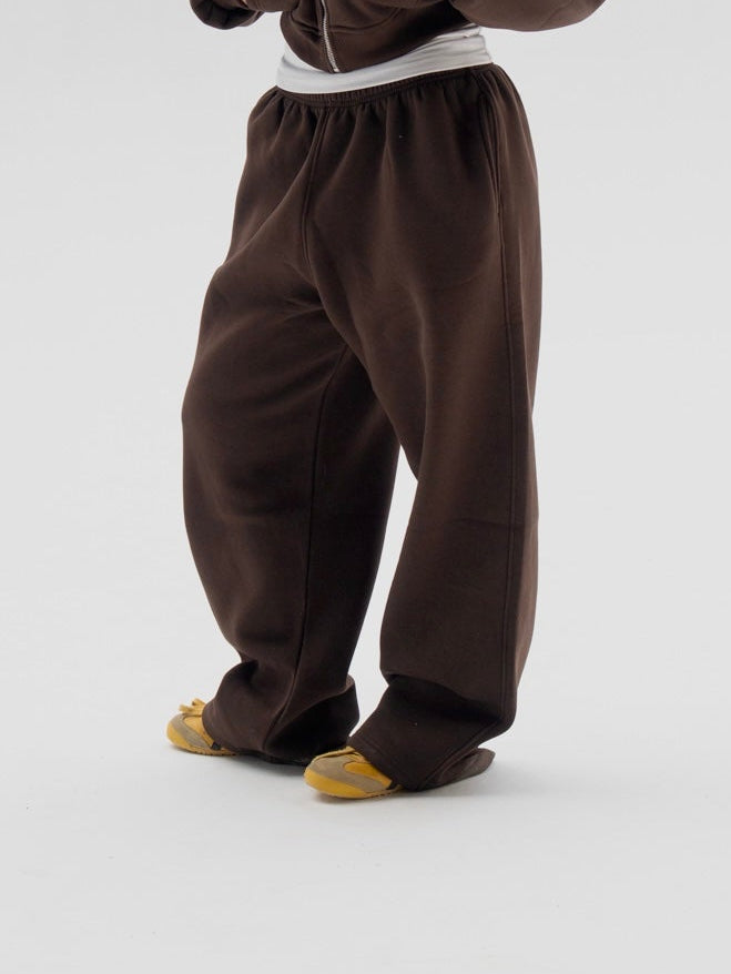 Person wearing a brown onesie on a white background