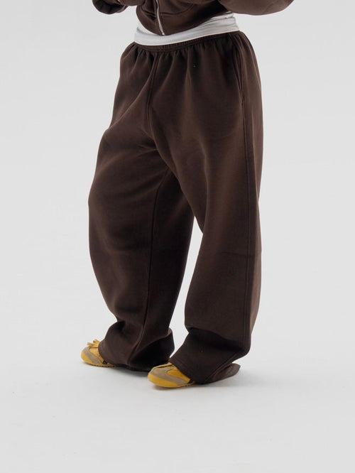 Person wearing a brown onesie on a white background